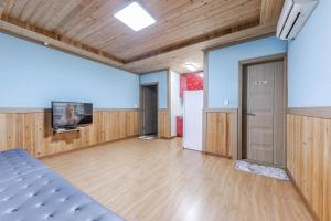 a large room with a bed and a tv in it at Suncheonman Muhan Dojan Pension in Suncheon