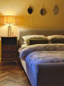 a bedroom with a bed and a night stand with a lamp at Kiltumper Lodge in Kilmihil