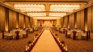 a banquet hall with tables and chairs and chandeliers at Pride Plaza Indore in Indore +71 photos