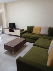 a living room with a green couch and a coffee table at SeaSideGolem Apartments in Golem