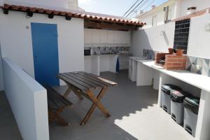 a kitchen with a wooden bench and a blue door at O Tourinho Baleal in Baleal
