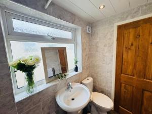 a bathroom with a sink and a toilet and a window at Bolton Terrace - 2 Bedrooms - Sleeps 4 in Workington