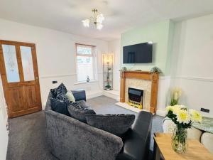 a living room with a couch and a fireplace at Bolton Terrace - 2 Bedrooms - Sleeps 4 in Workington
