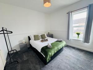 a white bedroom with a bed and a window at Bolton Terrace - 2 Bedrooms - Sleeps 4 in Workington