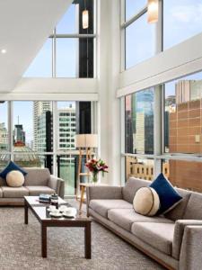 a living room with two couches and a table at Quest on William in Melbourne