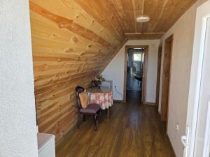 a hallway with a wooden ceiling with a table and chairs at Miris Katuna - Sinjajevina in Šavnik