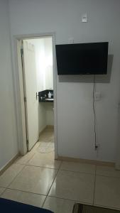 a room with a door with a television on the wall at Hostel Viracopos in Campinas +1 photo