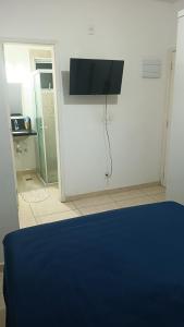 a bedroom with a bed and a tv on the wall at Hostel Viracopos in Campinas