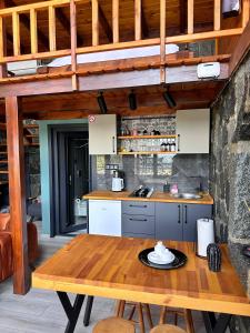 a kitchen with a wooden table and a counter top at Novella Bungalov in Işıklı +54 photos
