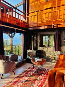 a living room with a fireplace and a stone wall at Novella Bungalov in Işıklı