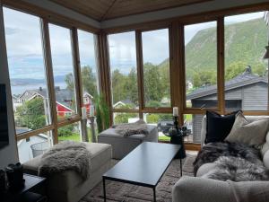 a living room filled with furniture and a large window at Tromsø Panorama in Tromsø