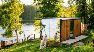 two people standing in front of a tiny house by a lake at WonderInn Riverside in Årnes +35 photos