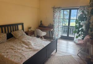 a bedroom with a bed and a desk and a window at Villa overlooking Lake Thiersee in Vorderthiersee