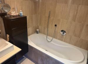 a bathroom with a bath tub and a sink at Villa overlooking Lake Thiersee in Vorderthiersee