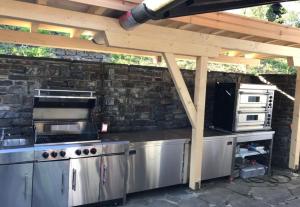an outdoor kitchen with a stove and a microwave at Villa overlooking Lake Thiersee in Vorderthiersee