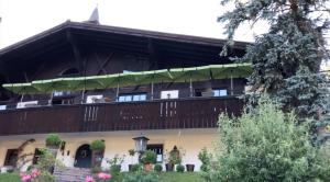 a large house with a balcony with a deck at Villa overlooking Lake Thiersee in Vorderthiersee