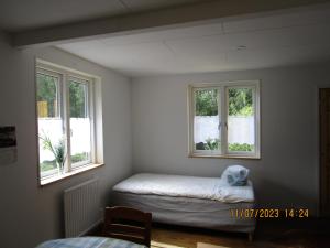 a room with two windows and a bed in it at Mysig huset in Strömsnäsbruk
