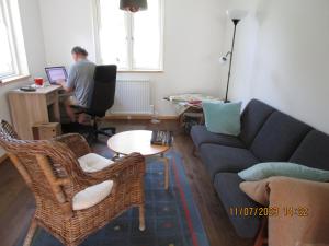 a man working on a computer in a living room at Mysig huset in Strömsnäsbruk +1 photo