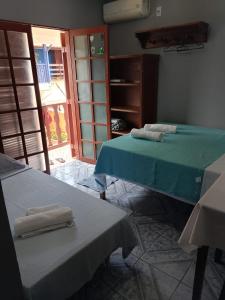 two beds in a room with towels on them at Trindade Flat Azulmar in Trindade