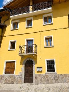 a yellow building with a balcony and a door at casa zanna bianca in Vione