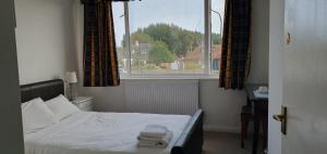 a small bedroom with a bed and a window at Seabrook House Hotel in Hythe