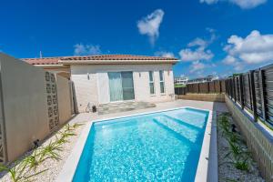 a swimming pool in the backyard of a house at Villa Arco Miyakojima in Miyako-jima
