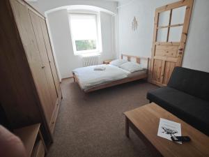 a small bedroom with a bed and a couch at Apartmán U Krtka in Lázně Kynžvart