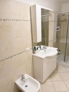 a white bathroom with a sink and a shower at casa zanna bianca in Vione