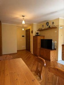 a living room with a wooden table and a flat screen tv at casa zanna bianca in Vione