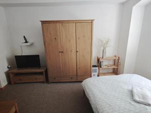 a bedroom with a bed and a wooden cabinet at Apartmán U Krtka in Lázně Kynžvart