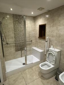 a bathroom with a shower and a toilet and a tub at PLUS PROPERTIES Leeds 6 in Bradford