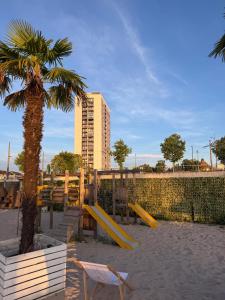 a playground with a palm tree and a yellow slide at Ferienwohnung Rheinblick in Kehl am Rhein