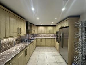 a kitchen with wooden cabinets and stainless steel appliances at PLUS PROPERTIES Leeds 6 in Bradford