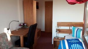 a room with a desk and a bedroom with a bed at Hotel-Pension-Waldblick in Mainhardt