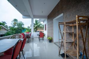 a room with a table and chairs and a wall at Seraya Stays in Mandrem