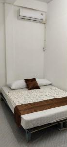 a white room with a bed with a pillow on it at Urban Nest Hostel in Bangkok