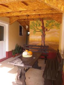 a picnic table in a building with a painting on the wall at Smeštaj Mevlida in Belo Blato