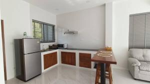 a kitchen with a refrigerator and a table and a chair at Green Mountain View villas Koh samui in Plai Laem
