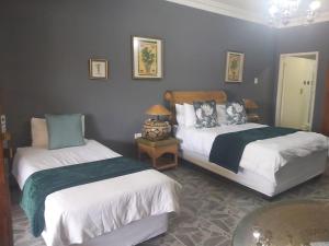 a bedroom with two beds and a table at Old Mine Guesthouse in Musina +47 photos