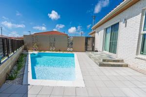 a swimming pool in the backyard of a house at Villa Arco Miyakojima in Miyako-jima