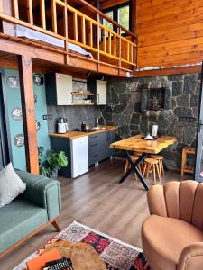 a kitchen and living room with a table and a counter at Novella Bungalov in Işıklı
