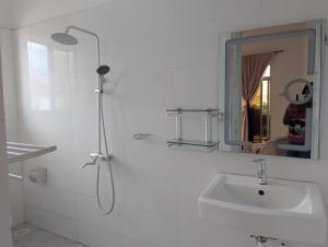 a white bathroom with a sink and a mirror at Nisandra Beach Hotel in Nungwi