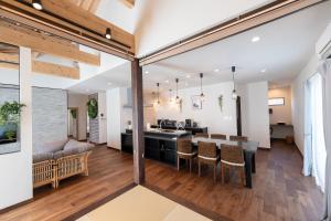 an open kitchen and living room with a dining room and a kitchen and dining table at Villa Arco Miyakojima in Miyako-jima