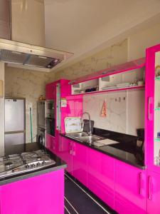 a pink kitchen with pink cabinets and appliances at Marrakech héberg in Marrakesh