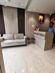a lobby with a couch and a reception desk at Hotel Sai Praatham in Shirdi