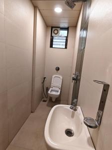 a bathroom with a sink and a toilet at Hotel Sai Praatham in Shirdi +18 photos