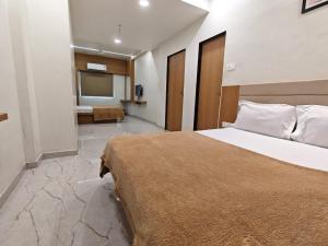 a bedroom with a large bed and a bathroom at Hotel Sai Praatham in Shirdi