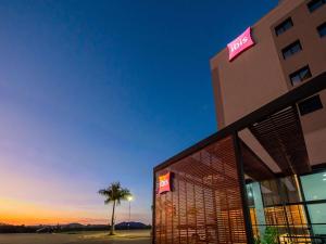 a hotel with a palm tree and a building at ibis Lavras in Lavras +95 photos
