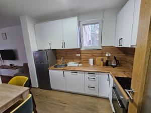 a kitchen with white cabinets and a sink at Luxury Apartment Lara Mostar in Mostar