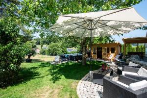 a patio with an umbrella and chairs and a table at Appartement Bergblick in Stockach